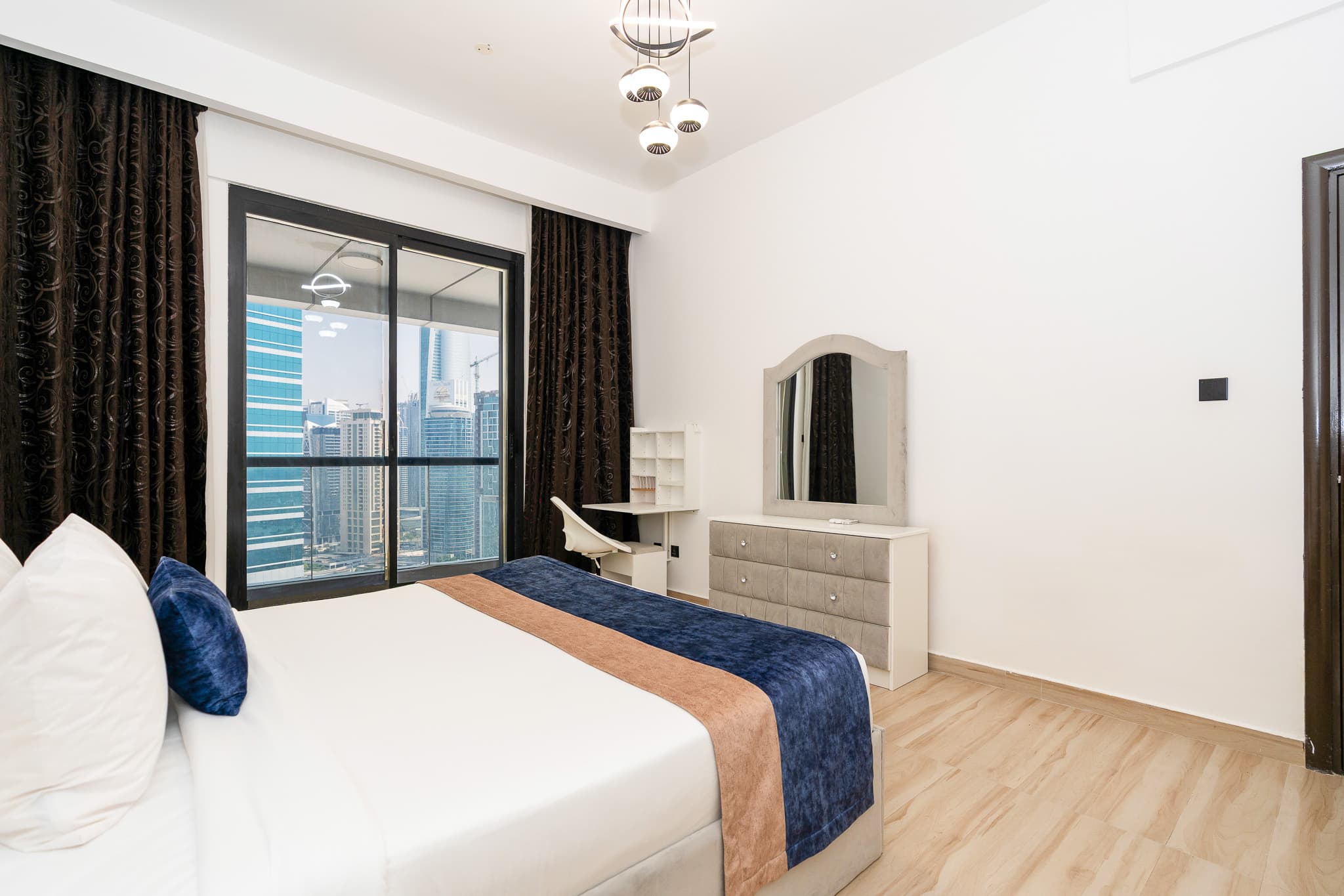 Bedroom with floor-to-ceiling window overlooking Dubai Marina towers